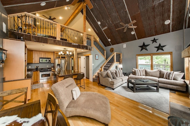 220 Brown Rd, Greers Ferry, AR 72067 - living area with high vaulted ceiling, ceiling fan, stairway, light wood finished floors, and a chandelier