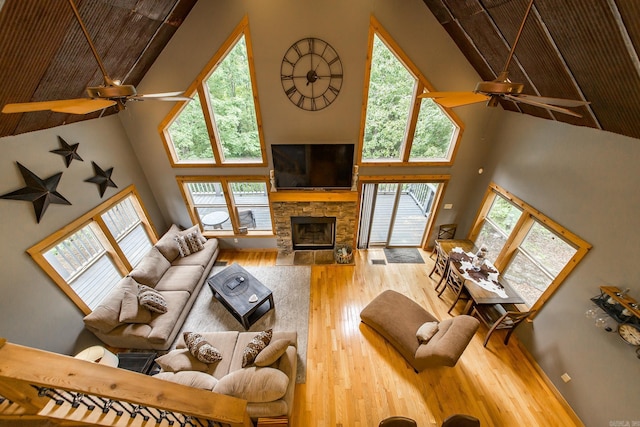 220 Brown Rd, Greers Ferry, AR 72067 - living room featuring a ceiling fan, high vaulted ceiling, hardwood / wood-style flooring, a stone fireplace, and plenty of natural light