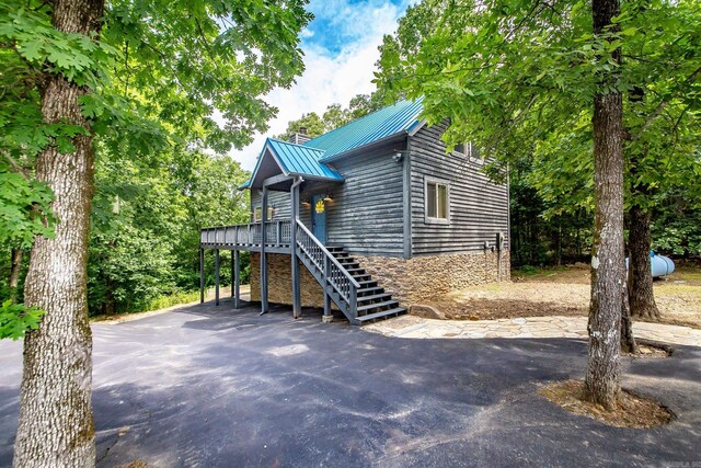 220 Brown Rd, Greers Ferry, AR 72067 - rustic home featuring a wooden deck, metal roof, stairs, a standing seam roof, and a chimney