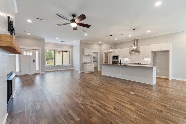 1569 Marquee Cir, Cabot, AR 72023 - unfurnished living room featuring ceiling fan, recessed lighting, dark wood finished floors, ornamental molding, and baseboards
