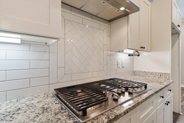 1569 Marquee Cir, Cabot, AR 72023 - kitchen with stainless steel gas stovetop, extractor fan, white cabinetry, and backsplash