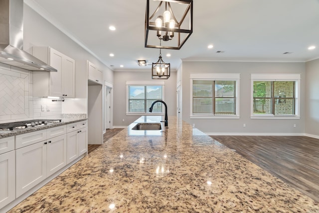 1569 Marquee Cir, Cabot, AR 72023 - kitchen featuring wall chimney range hood, a sink, a chandelier, stainless steel gas cooktop, and crown molding