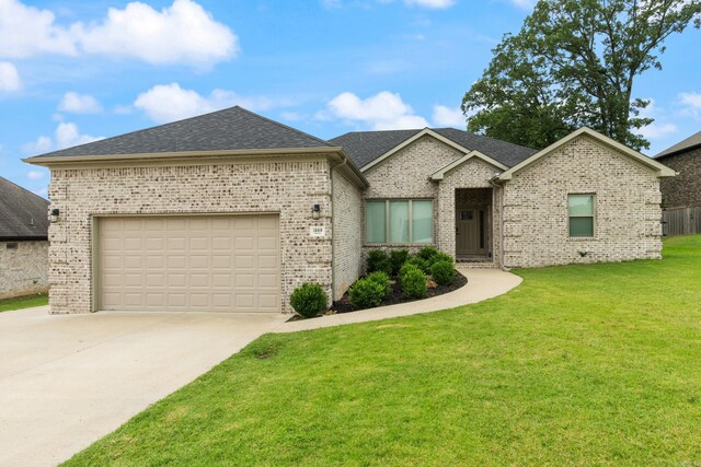 1569 Marquee Cir, Cabot, AR 72023 - view of front facade featuring brick siding, concrete driveway, a front lawn, an attached garage, and roof with shingles