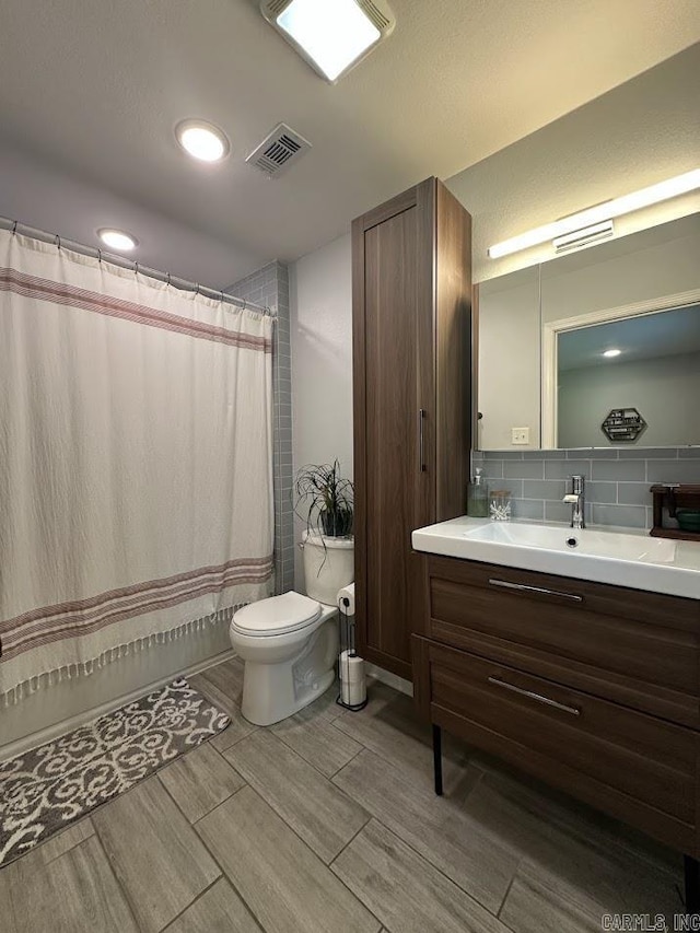 9 Whispering Dr, Alexander, AR 72002 - bathroom featuring toilet, vanity, wood finish floors, backsplash, and a shower with shower curtain