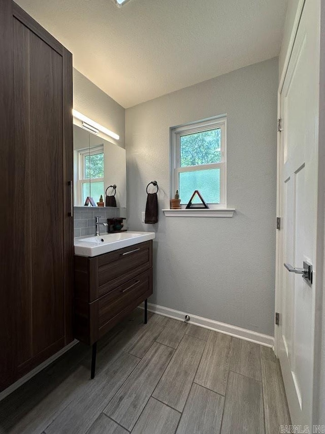 9 Whispering Dr, Alexander, AR 72002 - bathroom featuring vanity, wood finished floors, plenty of natural light, and baseboards
