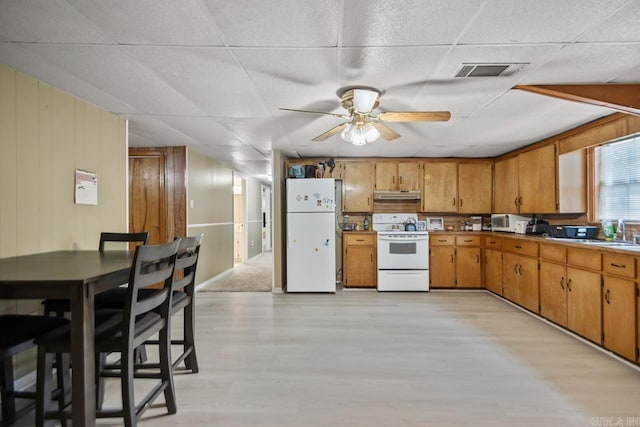 21 Evergreen Park, Cabot, AR 72023 - kitchen featuring white appliances, under cabinet range hood, light wood-style floors, ceiling fan, and brown cabinetry