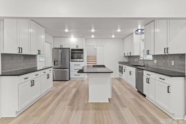 1506 N Pratt St, Pocahontas, AR 72455 - kitchen with appliances with stainless steel finishes, dark countertops, a sink, tasteful backsplash, and white cabinetry