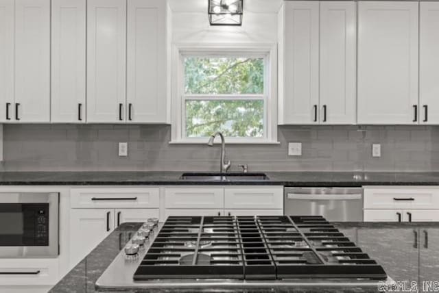 1506 N Pratt St, Pocahontas, AR 72455 - kitchen with stainless steel appliances, a sink, white cabinetry, and tasteful backsplash