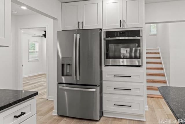 1506 N Pratt St, Pocahontas, AR 72455 - kitchen with appliances with stainless steel finishes, dark stone counters, light wood-type flooring, and ceiling fan