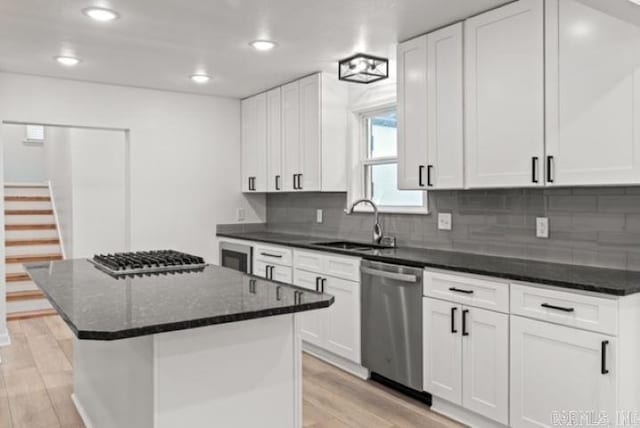 1506 N Pratt St, Pocahontas, AR 72455 - kitchen with appliances with stainless steel finishes, a sink, light wood finished floors, backsplash, and white cabinets