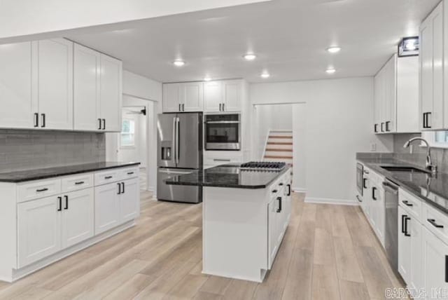 1506 N Pratt St, Pocahontas, AR 72455 - kitchen featuring stainless steel appliances, a sink, a center island, white cabinets, and light wood-style flooring