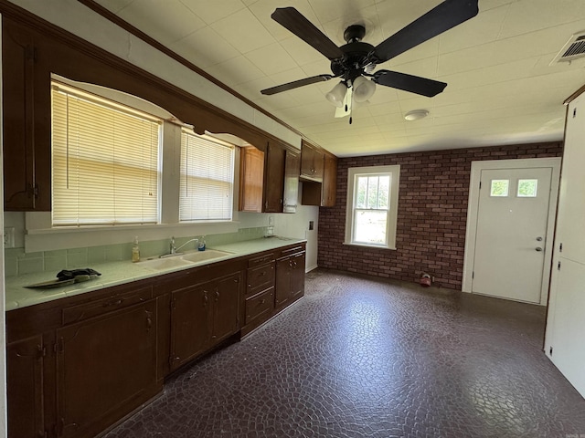 404 Mchenry, Malvern, AR 72104 - kitchen featuring brick wall, light countertops, ceiling fan, a sink, and dark flooring