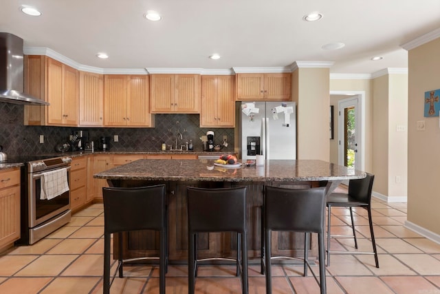 13 Heritage Park Cir, North Little Rock, AR 72116 - kitchen featuring appliances with stainless steel finishes, wall chimney exhaust hood, a breakfast bar, decorative backsplash, and light tile patterned floors