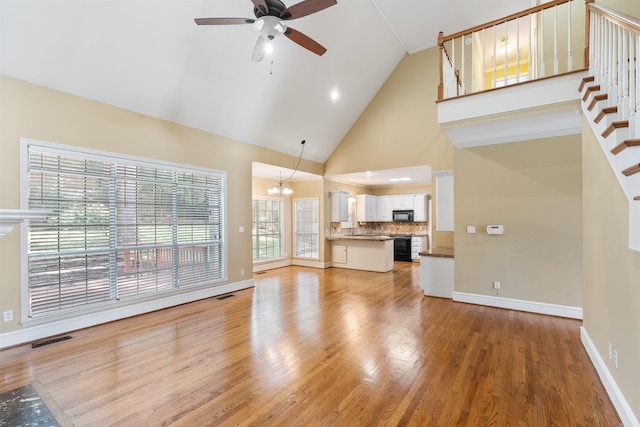 5 Cypress Pt, Little Rock, AR 72212 - unfurnished living room with a chandelier, ceiling fan, light wood-style flooring, high vaulted ceiling, and stairway