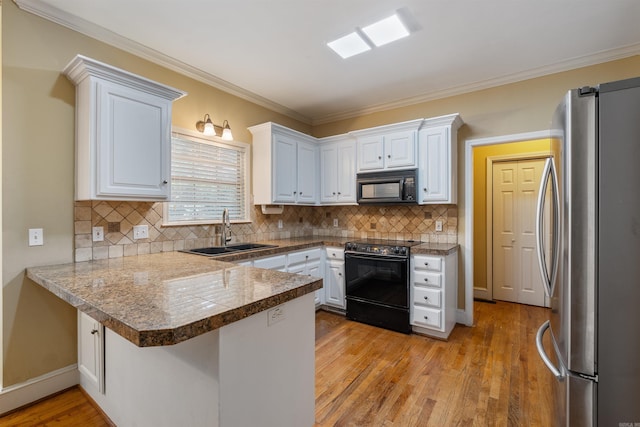 5 Cypress Pt, Little Rock, AR 72212 - kitchen featuring electric stove, freestanding refrigerator, black microwave, a sink, and a peninsula