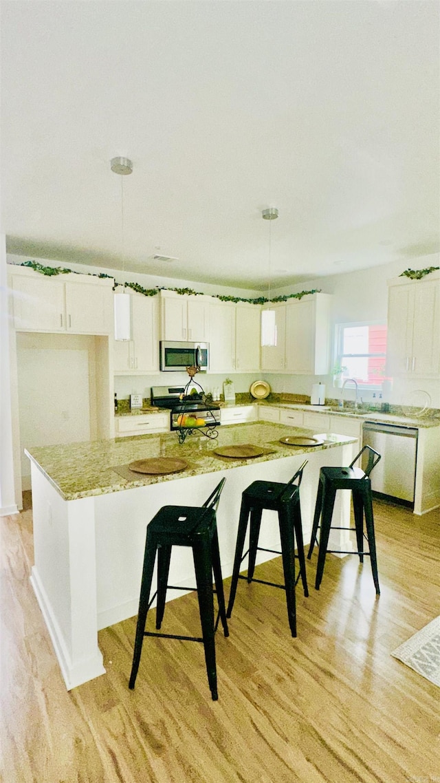 1418 S Martin St, Little Rock, AR 72204 - kitchen with stainless steel appliances, light wood-style flooring, and white cabinets