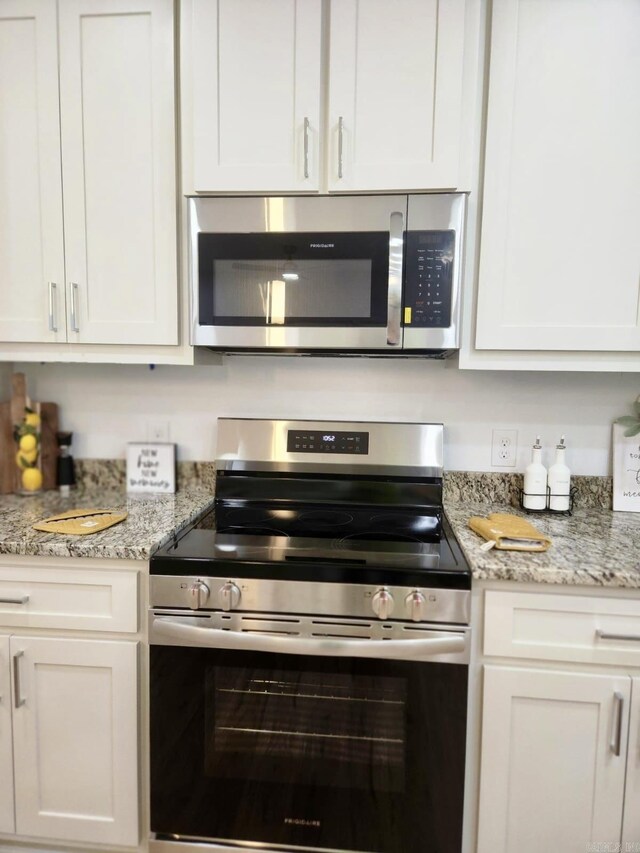 1418 S Martin St, Little Rock, AR 72204 - kitchen featuring stainless steel appliances, white cabinets, and light stone counters