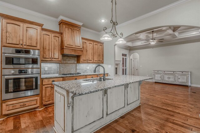 26 Kanis Creek Pl, Little Rock, AR 72223 - kitchen featuring arched walkways, a sink, stainless steel appliances, light stone countertops, and a ceiling fan