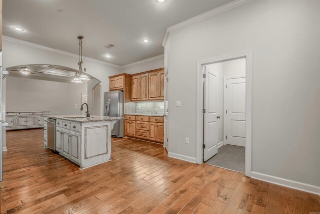 26 Kanis Creek Pl, Little Rock, AR 72223 - kitchen featuring stainless steel appliances, a sink, ornamental molding, arched walkways, and light wood-type flooring