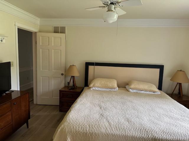1803 Fairwater Cir, Horseshoe Bend, AR 72512 - bedroom with wood finished floors, ornamental molding, and a ceiling fan