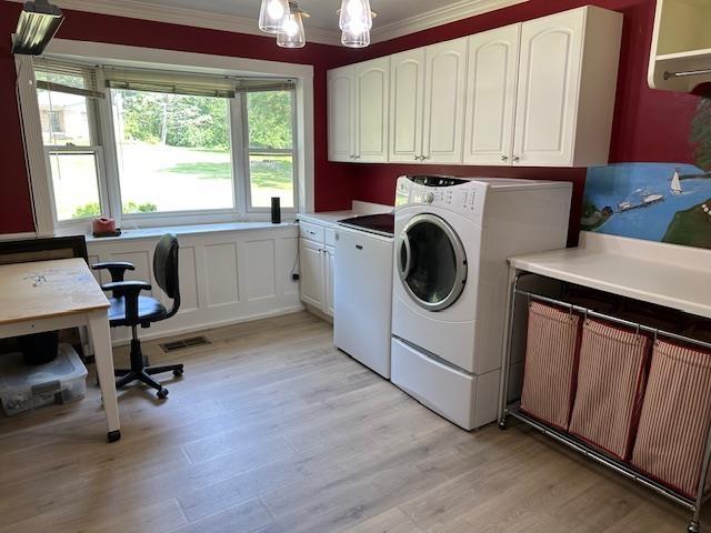 1803 Fairwater Cir, Horseshoe Bend, AR 72512 - laundry area featuring cabinet space, washer and clothes dryer, ornamental molding, light wood-style flooring, and a chandelier