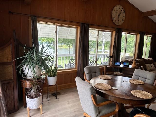 1803 Fairwater Cir, Horseshoe Bend, AR 72512 - dining room with wooden walls, light wood finished floors, lofted ceiling, and baseboards