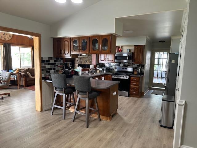 1803 Fairwater Cir, Horseshoe Bend, AR 72512 - kitchen with stainless steel appliances, a peninsula, dark countertops, backsplash, and a breakfast bar area