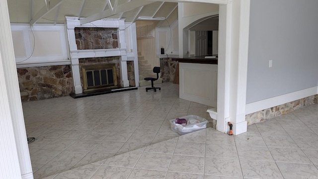 unfurnished living room with a stone fireplace and arched walkways