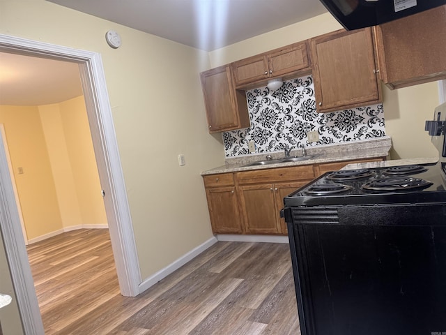1316-1318 W 13th St, Little Rock, AR 72202 - kitchen featuring black / electric stove, a sink, light wood-style floors, tasteful backsplash, and brown cabinets