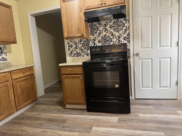 1316-1318 W 13th St, Little Rock, AR 72202 - kitchen featuring black / electric stove, under cabinet range hood, tasteful backsplash, brown cabinets, and light wood-style flooring