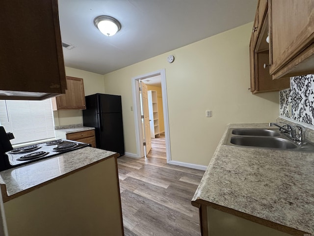 1316-1318 W 13th St, Little Rock, AR 72202 - kitchen featuring freestanding refrigerator, a sink, light wood finished floors, range, and baseboards