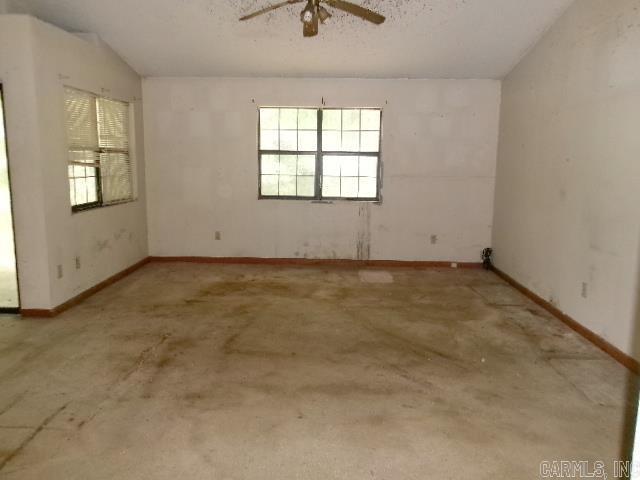 112 Huckleberry Ln, Monticello, AR 71655 - empty room featuring unfinished concrete flooring, ceiling fan, and baseboards