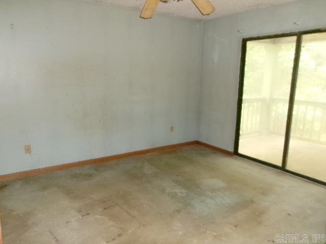 112 Huckleberry Ln, Monticello, AR 71655 - spare room featuring concrete floors, baseboards, and a ceiling fan