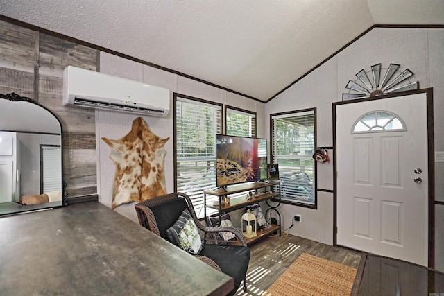 193 Sycamore, Sheridan, AR 72150 - foyer entrance with a wall mounted AC, vaulted ceiling, a textured ceiling, and wood finished floors