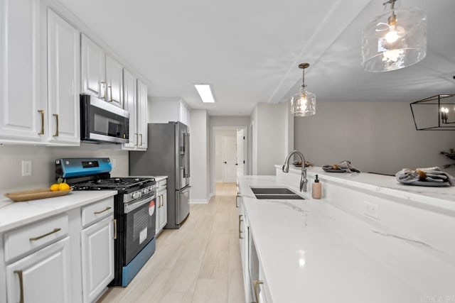 104 Dickson Dr, Little Rock, AR 72207 - kitchen with appliances with stainless steel finishes, a sink, white cabinets, and decorative light fixtures