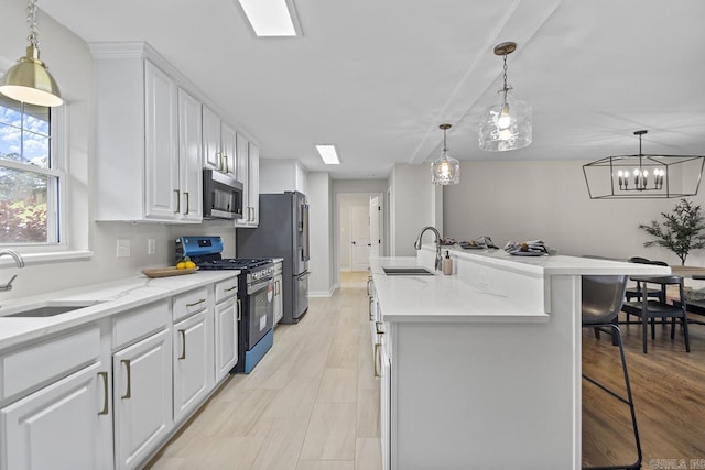 104 Dickson Dr, Little Rock, AR 72207 - kitchen featuring stainless steel appliances, a sink, a kitchen breakfast bar, and white cabinetry