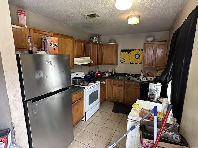 422 Mimosa Rd, North Little Rock, AR 72117 - kitchen featuring freestanding refrigerator, white electric range, under cabinet range hood, brown cabinetry, and a sink