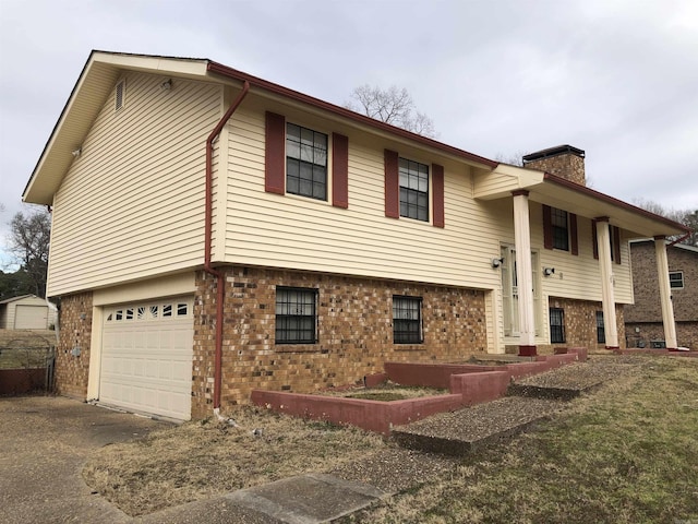6 Bryan Keith Ct, Little Rock, AR 72206 - view of front of home with brick siding, a chimney, an attached garage, and driveway