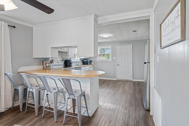 508 W Bell, Sheridan, AR 72150 - kitchen featuring electric range, dark wood finished floors, light countertops, white cabinetry, and ornamental molding