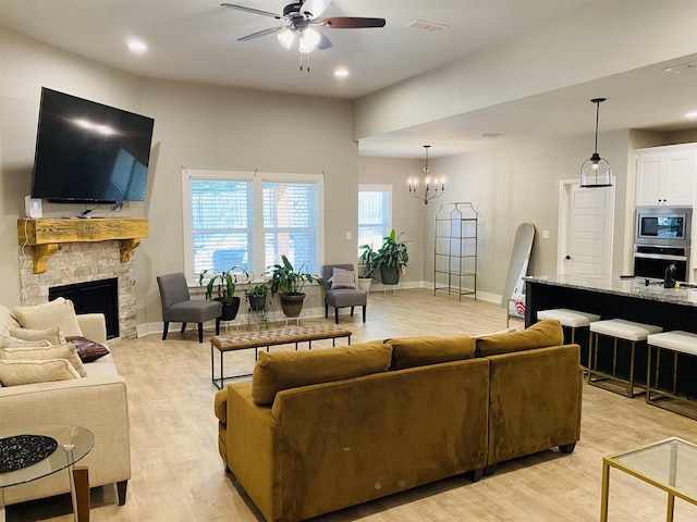 5104 Peace Ln, Alexander, AR 72002 - living area with ceiling fan, light wood-style flooring, a fireplace, a chandelier, and baseboards
