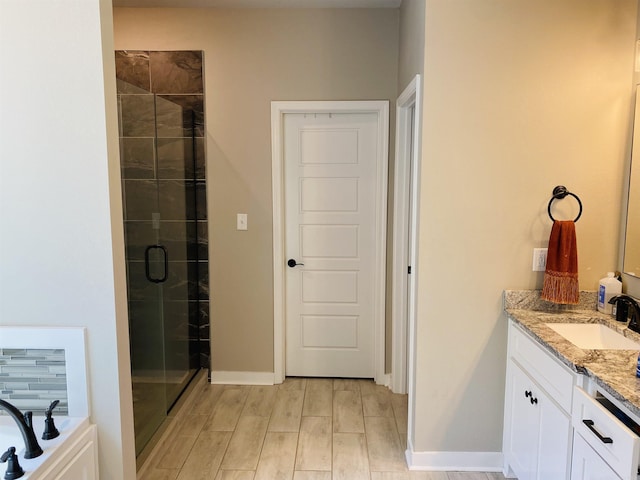 5104 Peace Ln, Alexander, AR 72002 - bathroom with a shower stall, vanity, wood finished floors, a garden tub, and baseboards