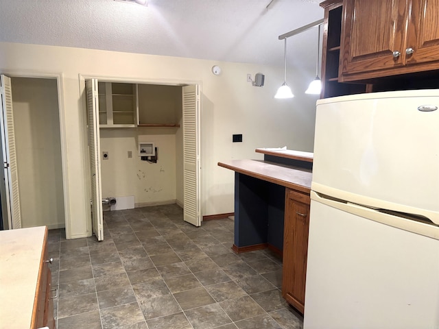 13 Page Cv, Maumelle, AR 72113 - kitchen with freestanding refrigerator, baseboards, light countertops, brown cabinets, and decorative light fixtures