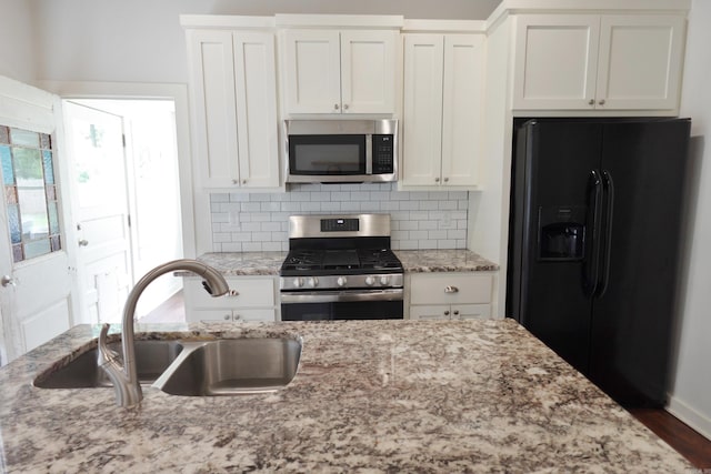 1365 Mitchell St, Conway, AR 72034 - kitchen with stainless steel appliances, a sink, white cabinets, and tasteful backsplash