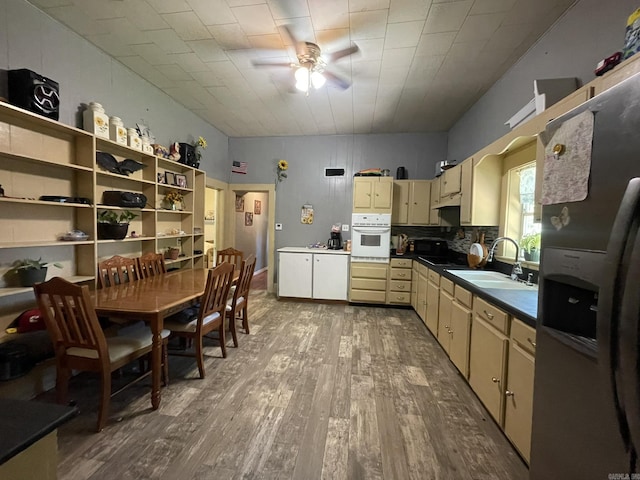 210 Gann St, Mena, AR 71953 - kitchen featuring stainless steel fridge with ice dispenser, a sink, white oven, a ceiling fan, and hardwood / wood-style flooring