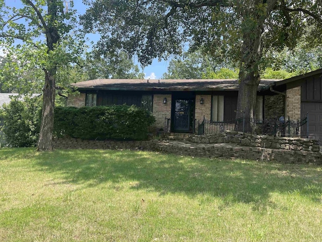 ranch-style home with a garage and a front lawn