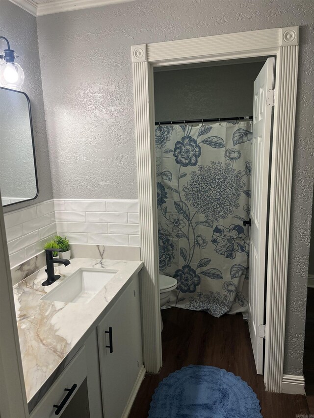 2715 Deer Xing, El Dorado, AR 71730 - full bathroom featuring a textured wall, toilet, vanity, wood finished floors, and decorative backsplash