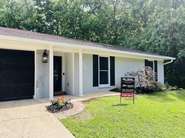 2715 Deer Xing, El Dorado, AR 71730 - view of front of property with brick siding, a front yard, an attached garage, and a shingled roof
