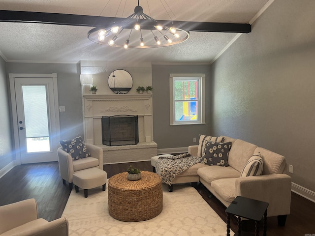 2715 Deer Xing, El Dorado, AR 71730 - living room with wood finished floors, a textured ceiling, a chandelier, a fireplace with raised hearth, and baseboards