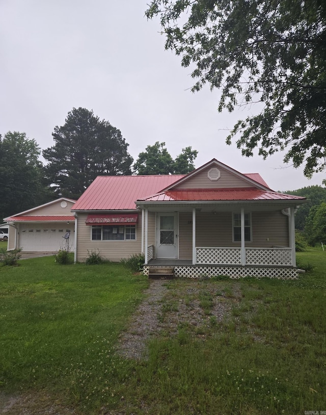 1851 W Clay, Piggott, AR 72454 - view of front facade featuring a porch, a front lawn, and metal roof