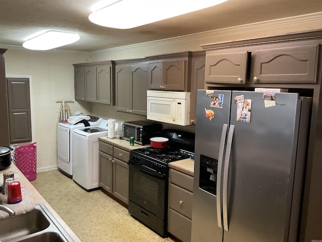 kitchen featuring separate washer and dryer, stainless steel refrigerator with ice dispenser, black gas range, white microwave, and light countertops